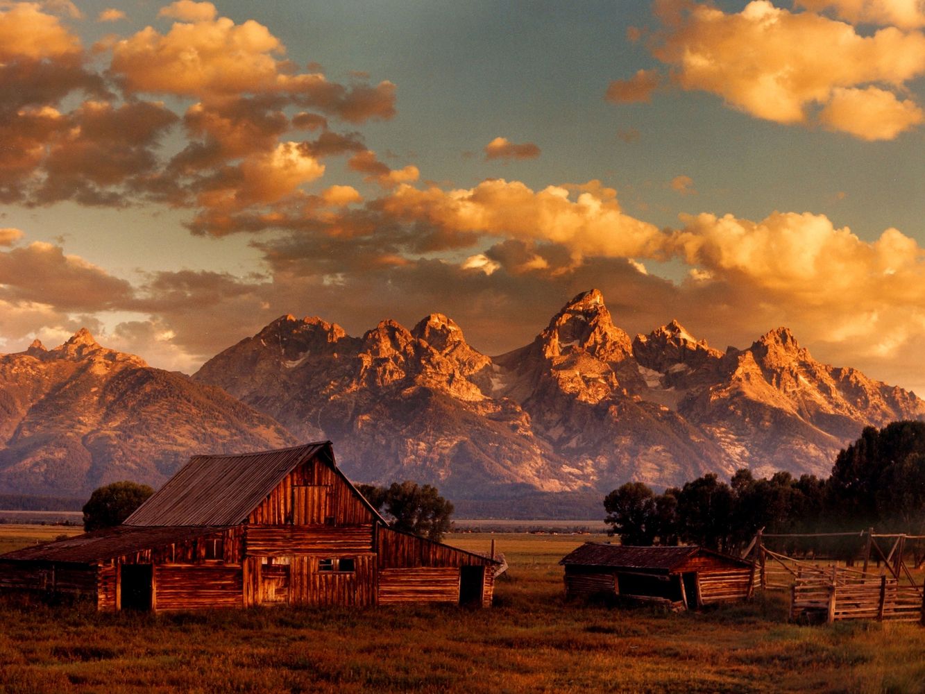 a rustic barn in front of a gorgeous view of the Tetons