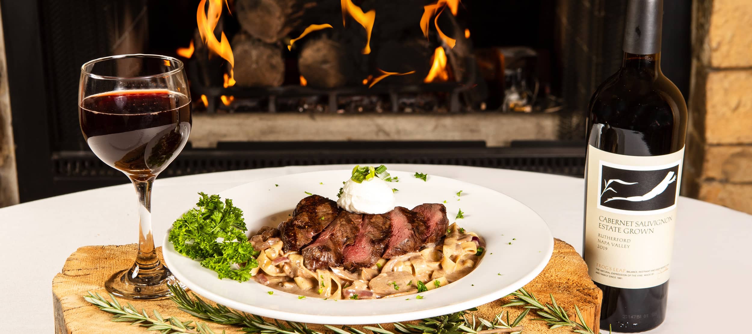 The Grizzly Steakhouse at Flying Saddle Resort — steak and wine by the fireplace in Alpine, Wyoming