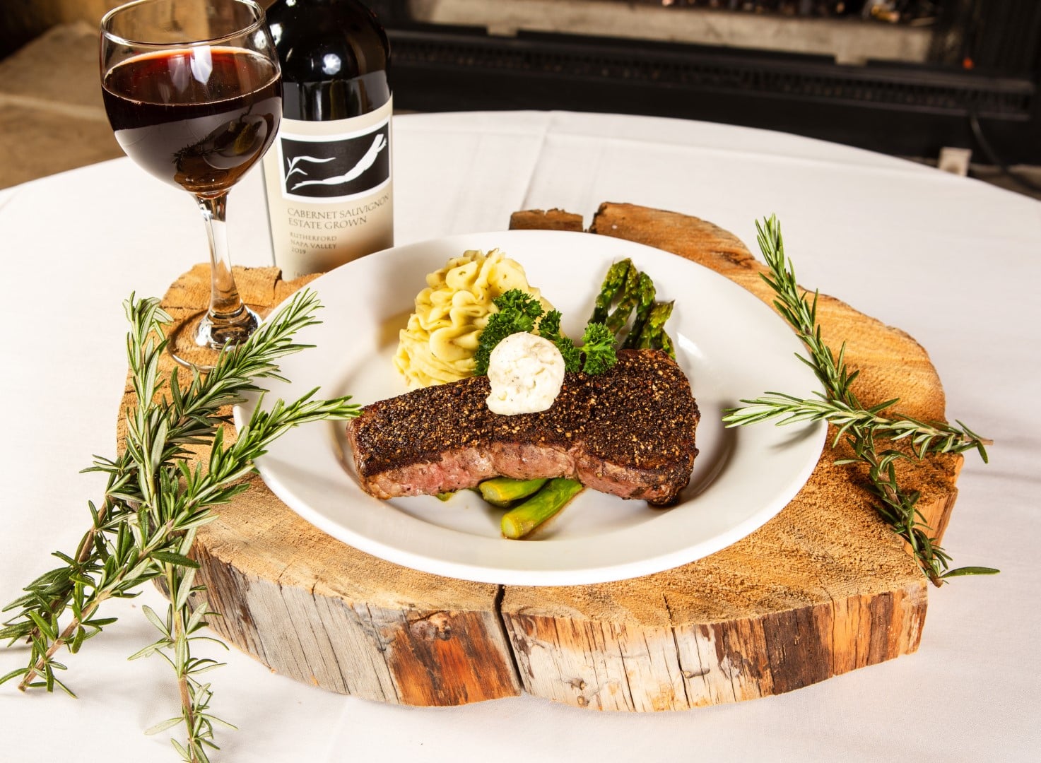 Pepper-crusted steak with mashed potatoes, asparagus, and Cabernet Sauvignon at The Grizzly Steakhouse